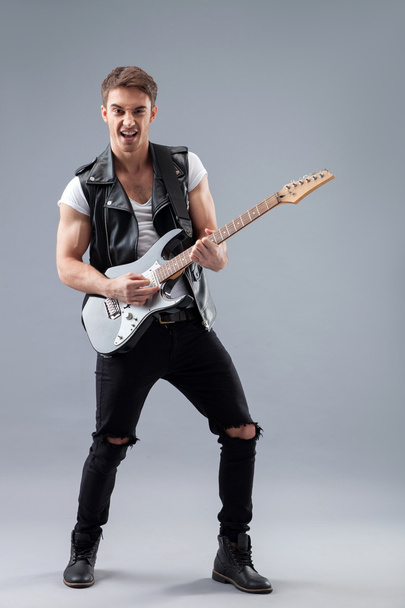Cheerful male rocker with cool musical instrument - Fotoğraf, Görsel