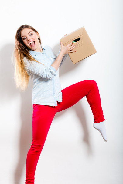 Happy woman moving into house carrying box. - Valokuva, kuva