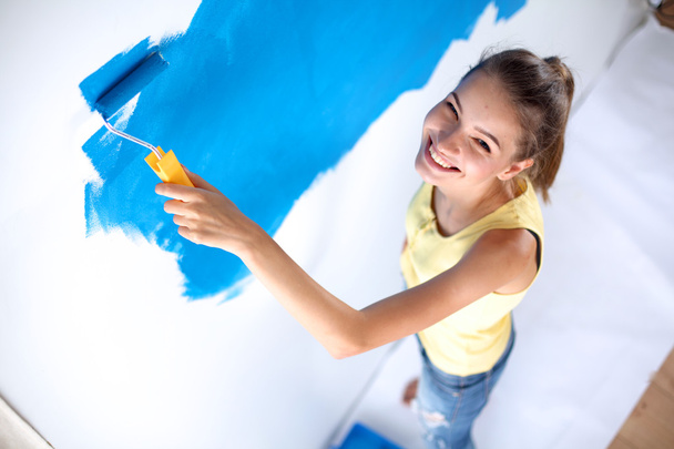 Szczęśliwa piękna młoda kobieta maluje ściany - Zdjęcie, obraz
