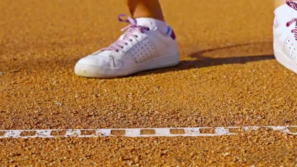 Tenisistka odbijając piłkę tenisową na kort tenisowy czerwony przed podaniem - Materiał filmowy, wideo