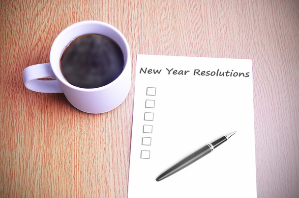 Café sobre a mesa com anotação escrevendo resoluções de ano novo
 - Foto, Imagem