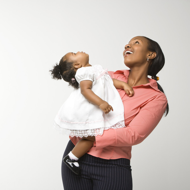 Woman holding infant girl. - 写真・画像