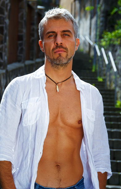 Seksikäs muoti muotokuva kuuma mies malli tyylikäs farkut ja paita lihaksikas kehon poseeraa. Wolves hammas korut riipus
 - Valokuva, kuva