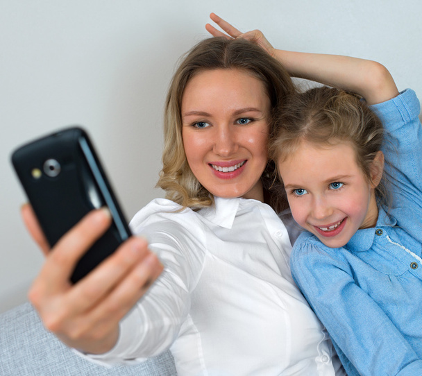 Мати і дочка беруть селфі з мобільним телефоном
. - Фото, зображення