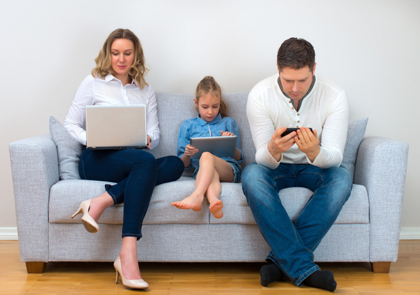 Valores familiares modernos. Padre, madre e hija usando dispositivos electrónicos
. - Foto, Imagen