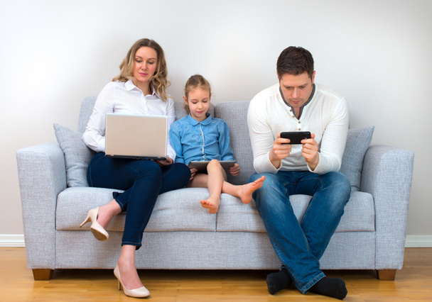 Moderní rodinné hodnoty. Otec, matka a dcera pomocí elektronických zařízení. - Fotografie, Obrázek