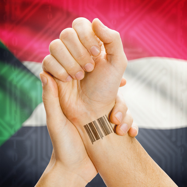 Barcode ID number on wrist and national flag on background series - Sudan - Foto, Imagen