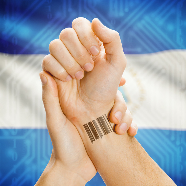 Barcode ID number on wrist and national flag on background series - Nicaragua - Foto, Imagen