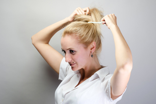 Young attractive happy laughing blonde woman make hair, updo - Fotografie, Obrázek