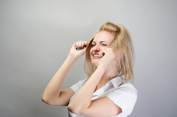 Young attractive happy laughing blonde woman make hair, updo - Foto, afbeelding