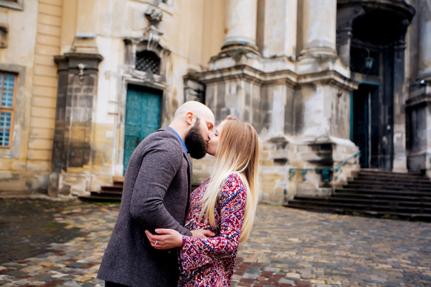 Young fashion elegant stylish couple posing on streets of european city in summer evening weather. Sensual blonde vogue girl with handsome hipster man having fun outdoor. - Fotó, kép