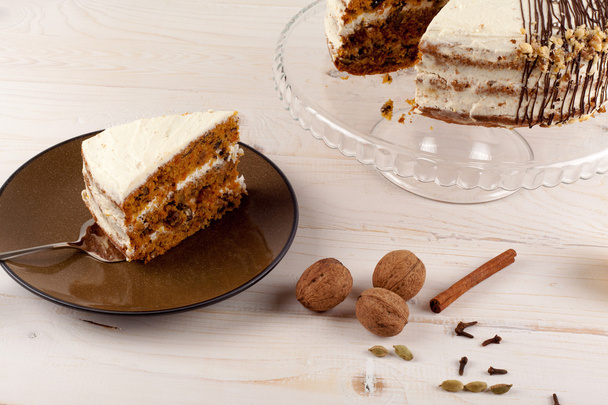 Carrot cake with walnuts and white cream. - Photo, image