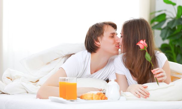 любляча пара цілується і снідає в ліжку
 - Фото, зображення