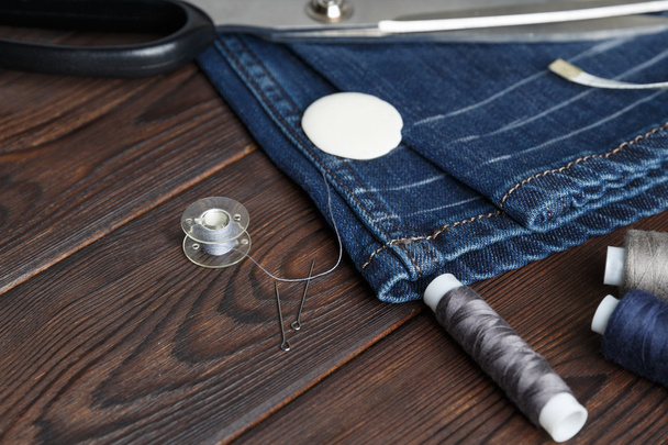 Calça jeans com costura utensílios de costura bordado
 - Foto, Imagem