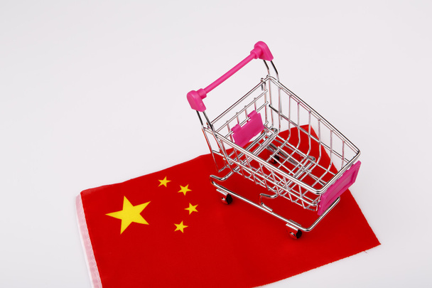 pink shopping cart on china flag - Foto, imagen