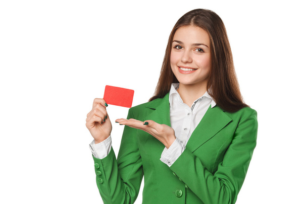Mujer de negocios sonriente mostrando la tarjeta de crédito en blanco en traje verde, aislado sobre blanco
 - Foto, Imagen