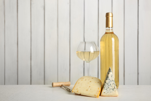 Wine and cheese on wooden wall  - Foto, imagen