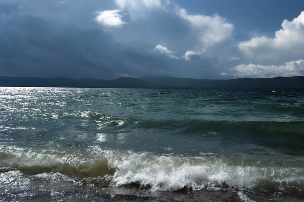 de achtergrond van de zandstranden, golven en storm wolken boven de - Foto, afbeelding