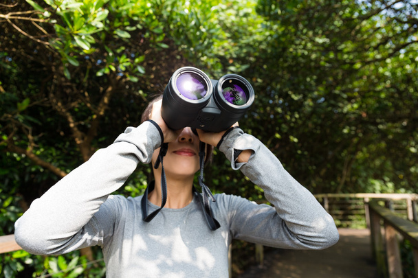 woman using binoculars at forest - Photo, Image
