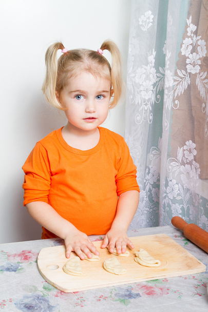маленька дівчинка робить тісто на кухні
. - Фото, зображення