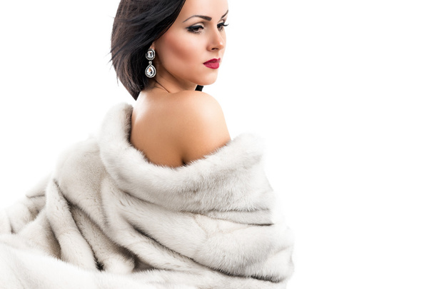 Portréja egy gyönyörű fiatal nő, egy nerc kabátot, fehér alapon - Fotó, kép