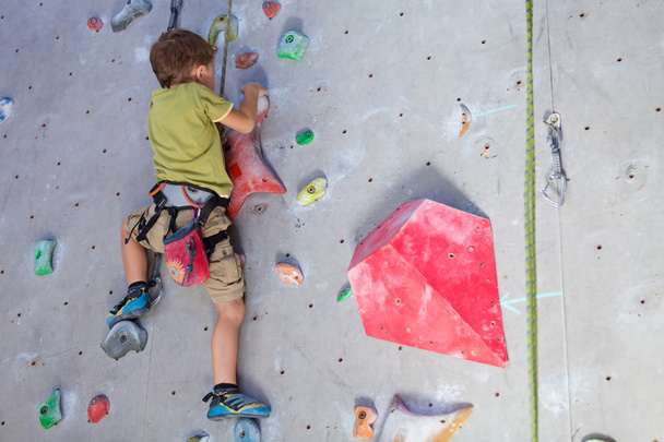 little boy climbing a rock wall - Фото, зображення