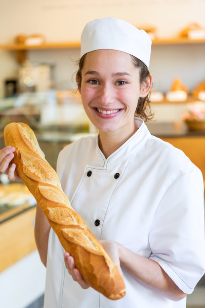 Junge Bäckerin arbeitet in der Bäckerei - Foto, Bild