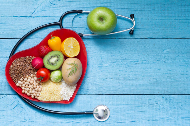 Food on heart plate with stethoscope cardiology concept - Photo, Image