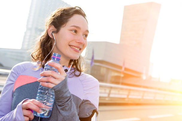 Woman drinking water during a running session - Foto, Imagen