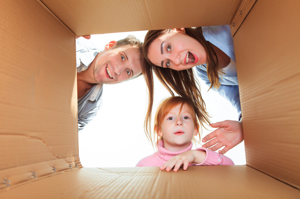 Family in a cardboard box ready for moving house - Фото, зображення