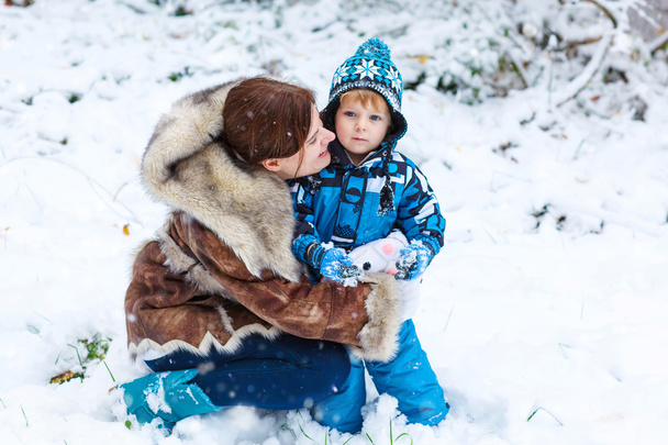 Gelukkig kind en moeder plezier met sneeuw in de winter - Foto, afbeelding