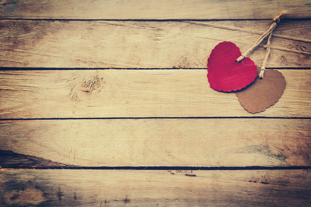 Dvě červené a hnědé srdce na dřevěné pozadí s vintage stylu. - Fotografie, Obrázek