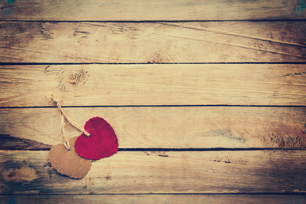 Two red and brown heart on wooden background with vintage style. - Photo, Image
