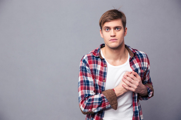 Stunned dazed man in checkered shirt with hand on chest - Fotoğraf, Görsel