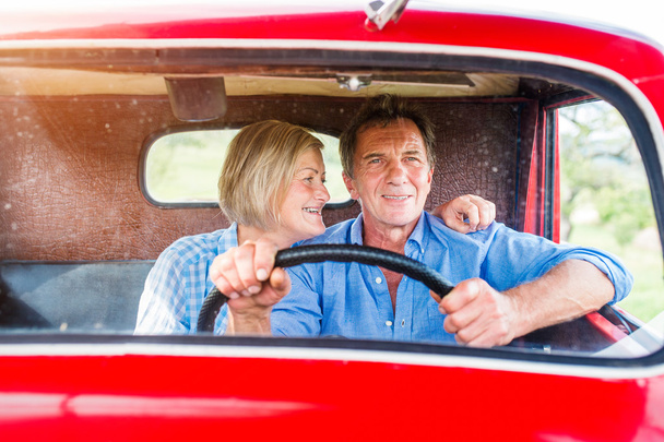 Senior couple in red car - Photo, Image