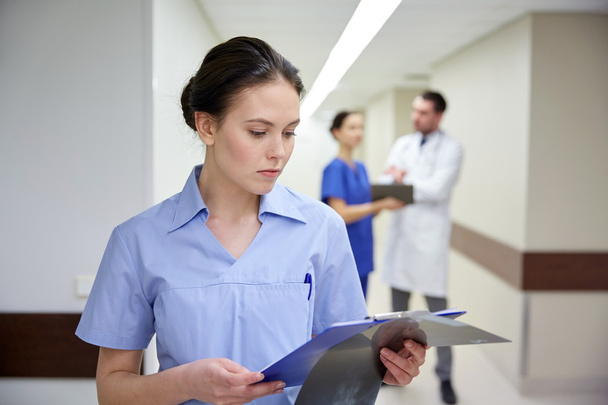 female doctor or nurse with clipboard at hospital - Foto, afbeelding