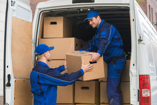 Delivery Men Unloading Boxes From Truck - 写真・画像