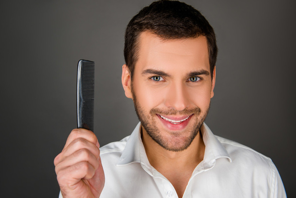 Cheerful man holding a comb - Фото, изображение