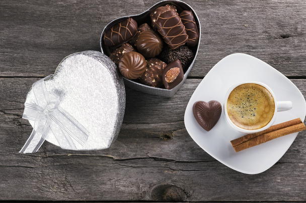 Box of chocolates, cup of coffee on a wooden background. Top vie - Фото, зображення