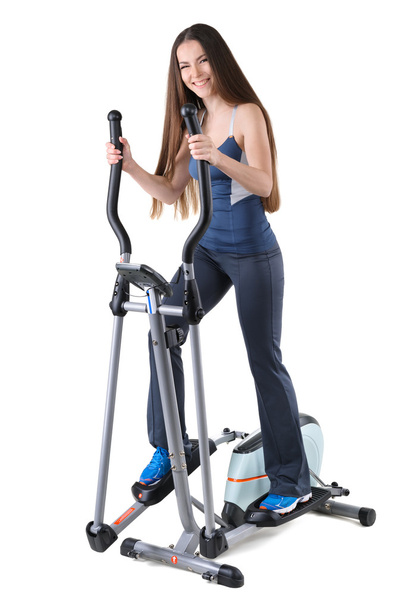 Jeune femme faisant des exercices sur l'entraîneur elliptique
 - Photo, image