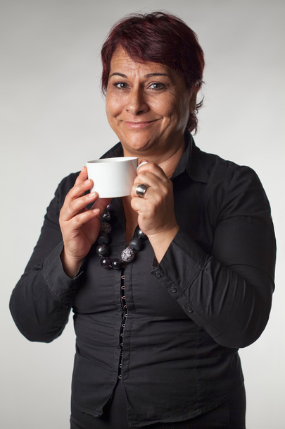 Mature woman holding a coffee cup - Fotó, kép