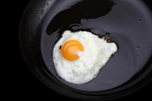Fried eggs on black pan - Foto, imagen