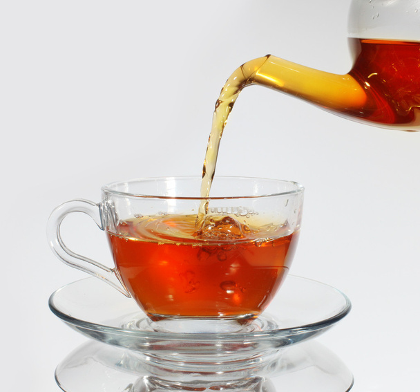 Pouring tea to a teacup - Photo, image