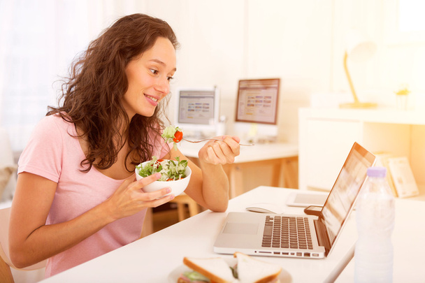 Young attractive student eating while working - Foto, Imagem