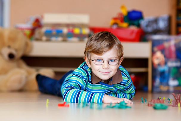 Junge spielt im Kinderzimmer mit Spielzeugsoldaten - Foto, Bild