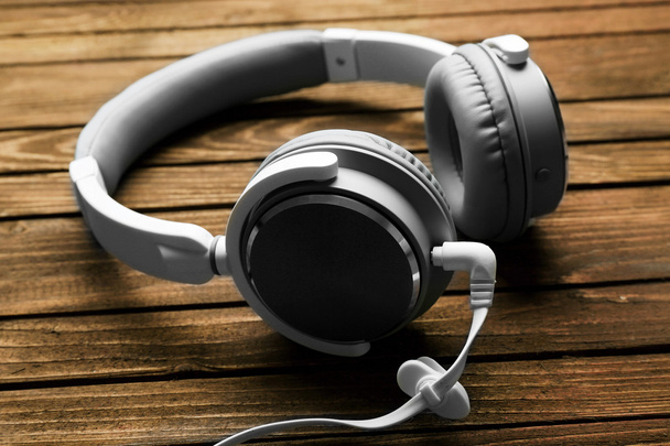 Headphones on brown wooden background - 写真・画像