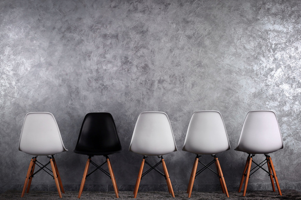 Stylish conception with white and black chairs on grey background - Foto, Imagem