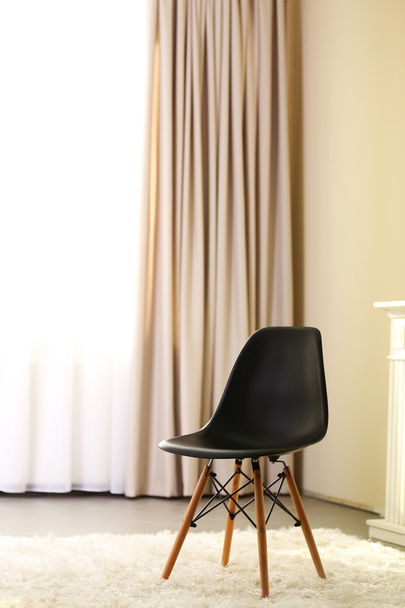 Concepção elegante com cadeira preta no fundo da sala de luz
 - Foto, Imagem