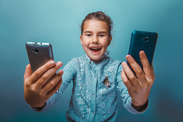 menina adolescente de aparência europeia sete anos, segurando dois tel
 - Foto, Imagem