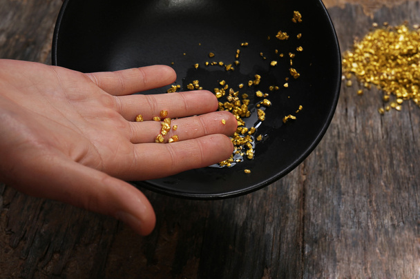 A hand holding gold nugget grains - Φωτογραφία, εικόνα